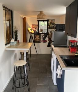 Una cocina con una encimera y algunos taburetes en ella. en Cinema & Netflix a La Roche, en La Roche-sur-Yon