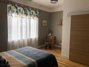 une chambre avec un lit et une fenêtre avec une chaise dans l'établissement Chambres et table d'hôtes Le Pontet, à Arthès