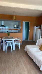 a living room with a table and chairs and a kitchen at Hostel Feminino Sol de Maria in Salvador