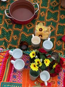 a table topped with bowls and flowers and a pot at Hostel Feminino Sol de Maria in Salvador +20 photos