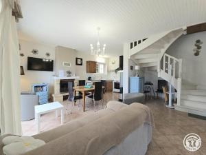 un salon avec un canapé et une salle à manger dans l'établissement Gite du soleil levant, à Lacropte