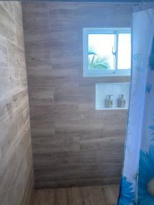 a bathroom with a wooden wall with a window at Mi Rinconcito in Colorado