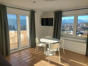 een eetkamer met een tafel en stoelen en grote ramen bij Ferienwohnung Amseltraum in Seeboden +5 foto's