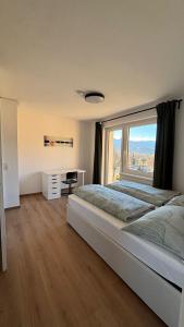 een slaapkamer met een groot bed met een groot raam bij Ferienwohnung Amseltraum in Seeboden