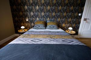 a bedroom with a bed with two lamps on tables at Chambres et table d'hôtes Le Pontet in Arthès