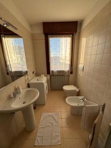 un bagno con un lavandino, un water e un lavandino di OTB Italia 6 - Rifugio moderno tra Venezia e Treviso con 2 terrazze e Parcheggio coperto a Preganziol