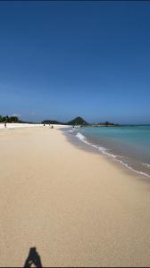 Der Schatten einer Person, die am Strand steht in der Unterkunft Cozy Homes BnB in Prampuan