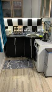 a kitchen with a washing machine and a sink at Safar in Karakol +10 photos