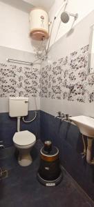 a bathroom with a toilet and a sink at Hotel Anbu Airport in Chennai