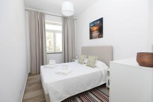 a white bedroom with a bed and a window at B50 - Main Square Apartment in Lagos in Lagos