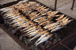 a bunch of fish cooking on a grill at B50 - Main Square Apartment in Lagos in Lagos
