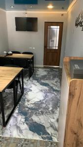a room with a marble floor with tables and a door at Safar in Karakol