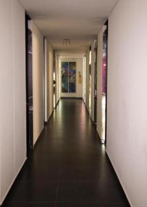 un pasillo con un largo pasillo con puertas y suelo de baldosa en Hotel Medellin Arte, en Medellín