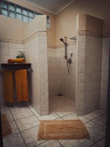 a bathroom with a shower with a wooden rug at Ayurveda Spring Of Life Resort in Piliyandala