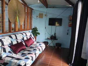 uma sala de estar com um sofá e uma TV de tela plana em Oceanfront Guest House em Puerto Galera