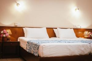 a hotel room with two beds with white pillows at Ayurveda Spring Of Life Resort in Piliyandala +7 photos