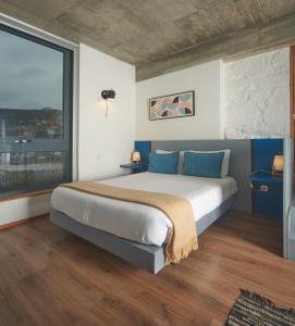 Un dormitorio con una cama grande y una ventana grande. en Bridge It - Suites & Views, en Vila Nova de Gaia