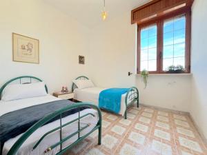 a bedroom with two beds and a window at Casa Tonia - Baia Verde in Baia Verde