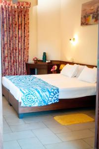 a bedroom with a bed with a blue and white comforter at Ayurveda Spring Of Life Resort in Piliyandala