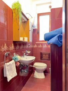 a red bathroom with a toilet and a sink at Casa Tonia - Baia Verde in Baia Verde +42 photos