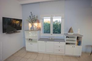 une cuisine blanche avec un comptoir et une fenêtre dans l'établissement Notos Villas, à Frangokastello