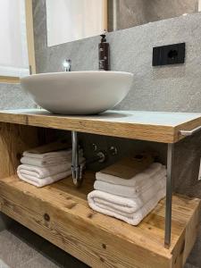 um lavatório de casa de banho num balcão de madeira com toalhas em Gran Zebrú B&B - high mountain em Valfurva