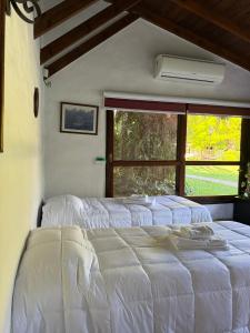 un letto bianco in una stanza con una finestra di LPR EZE Airport a La Unión