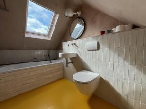 een badkamer met een toilet, een wastafel en een spiegel bij Luna in Camber