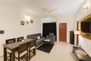 a living room with a dining table and a couch at The Cozy Chapter in Arpora