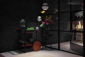 a black room with a vase of flowers on a shelf at Radisson Blu Hotel, London Leicester Square in London