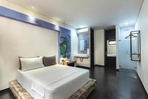 a bedroom with a white bed and a bathroom at Hotel Medellin Arte in Medellín