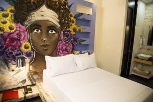 a bedroom with a painting of a black woman at Hotel Medellin Arte in Medellín