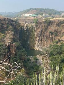 a waterfall on the side of a mountain at Staeg Dharashray Farm in Indore