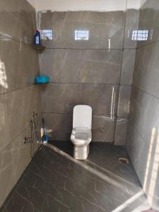 a small bathroom with a toilet in a stall at Staeg Dharashray Farm in Indore