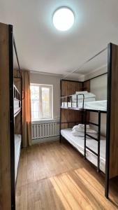 比什凯克Sayakatchy hostel的有三张双层床和一扇窗户的房间