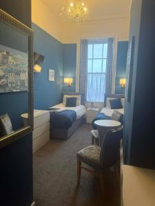 Una habitación de hotel con dos camas y un espejo. en The Jubilee Hotel West- with NEWLY REFURBISHED SPA FACILITIES - GAMESPIT - AND SMOKEHOUSE, en Weymouth