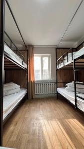 比什凯克Sayakatchy hostel的铺有木地板的客房内设有两张双层床。