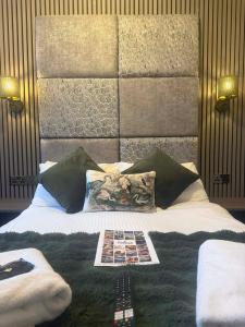 Una cama con un cabecero con una revista encima. en The Jubilee Hotel West- with NEWLY REFURBISHED SPA FACILITIES - GAMESPIT - AND SMOKEHOUSE, en Weymouth