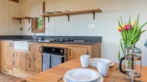 利德尼Betty Shepherd's Hut的厨房配有木桌和盘子