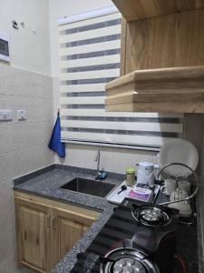 een kleine keuken met een spoelbak en een fornuis bij Kibs apartments in Dodoma