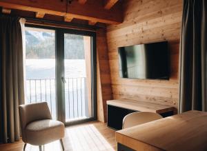 a living room with a television and a table and chairs at Les Chalets de Pierrot in Cogne