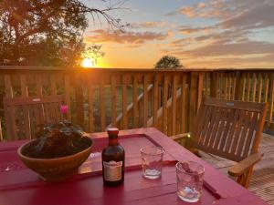 Una botella de vino sobre una mesa en una terraza. en West Coast Whistlestop, en Ochiltree