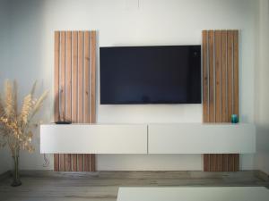 a white entertainment center with a flat screen tv at El Origen in Carboneras de Guadazaón