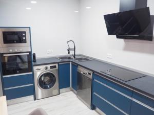 a kitchen with a sink and a washing machine at El Origen in Carboneras de Guadazaón +5 photos