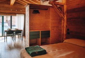 a bedroom with a bed and a table with chairs at Les Chalets de Pierrot in Cogne