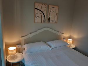Un dormitorio con una cama blanca con dos lámparas. en Gerenzano Apartments, en Gerenzano
