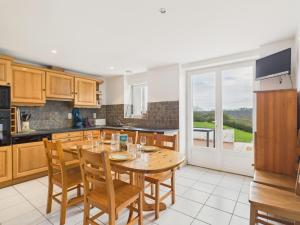 Maison de campagne pour 6 في Commequiers: مطبخ مع طاولة خشبية مع كراسي وطاولة