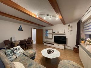 una sala de estar con un sofá y una mesa en Ferienwohnung Matthias Lang, en Rugendorf