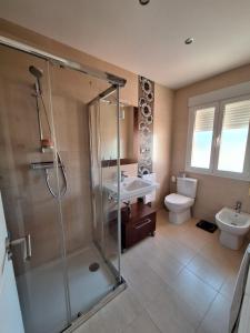 een badkamer met een douche, een toilet en een wastafel bij Vista Noguera in Huéscar