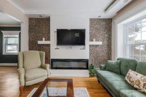 a living room with a couch and a tv at Fairmont Rooms in Worcester
